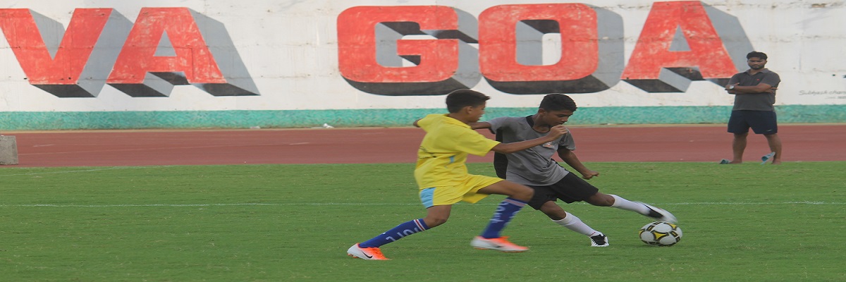 Boys training on the GFDC field, dribbling past cones in coaching drills.
